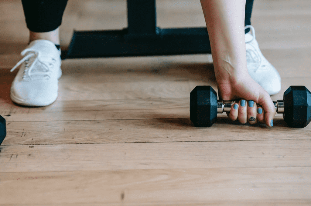 Women lifting weights at home after starting a workout routine.