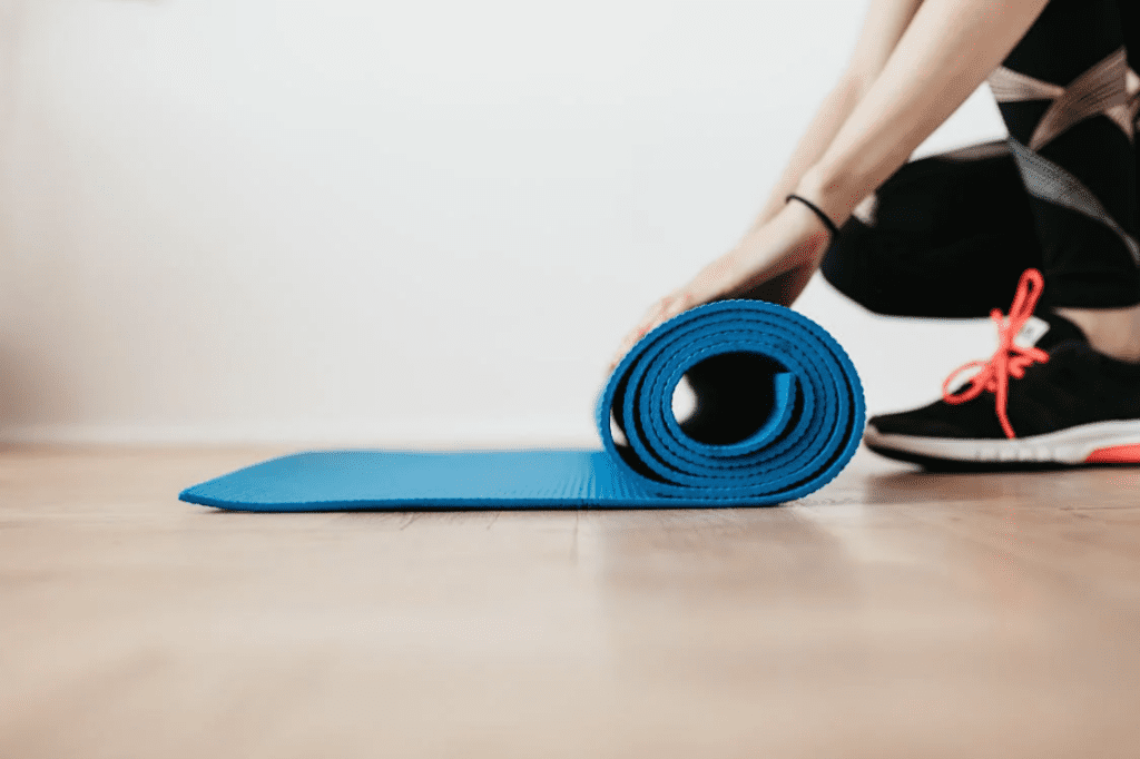 Confident women unrolling her yoga mat in the gym
