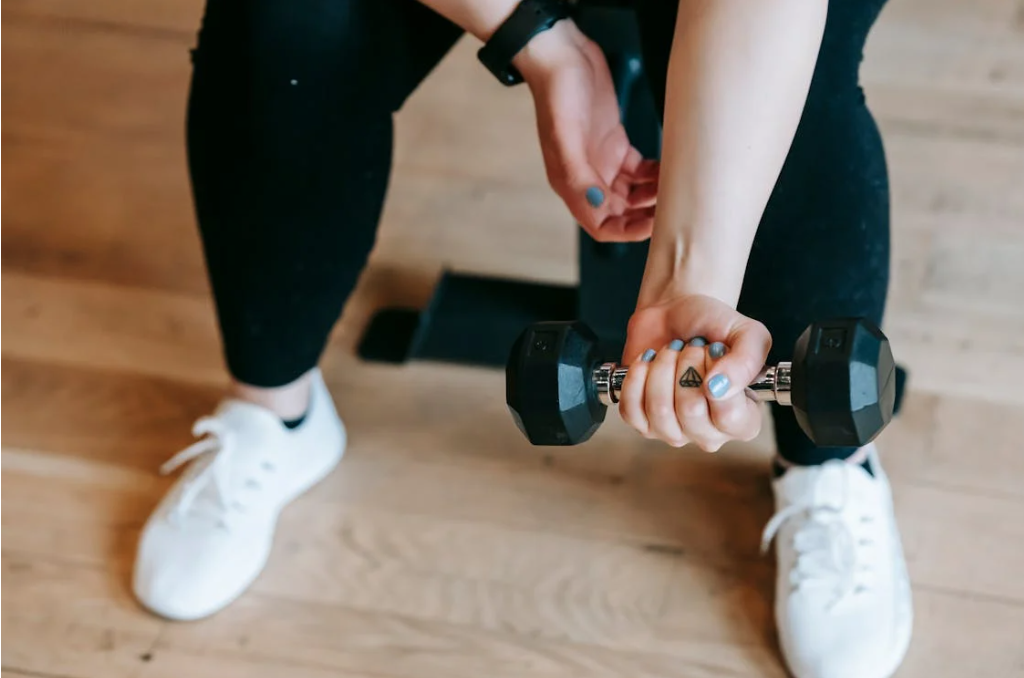 Women lifting dumbbels in the gym but not seeing muscle gains or progress