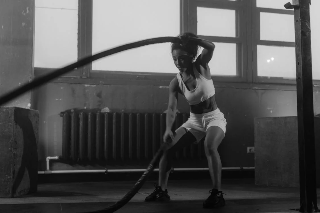 Woman performing a high intensity, full body workout in the gym